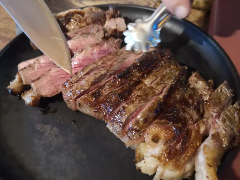 Chuletón a la brasa siendo troceado